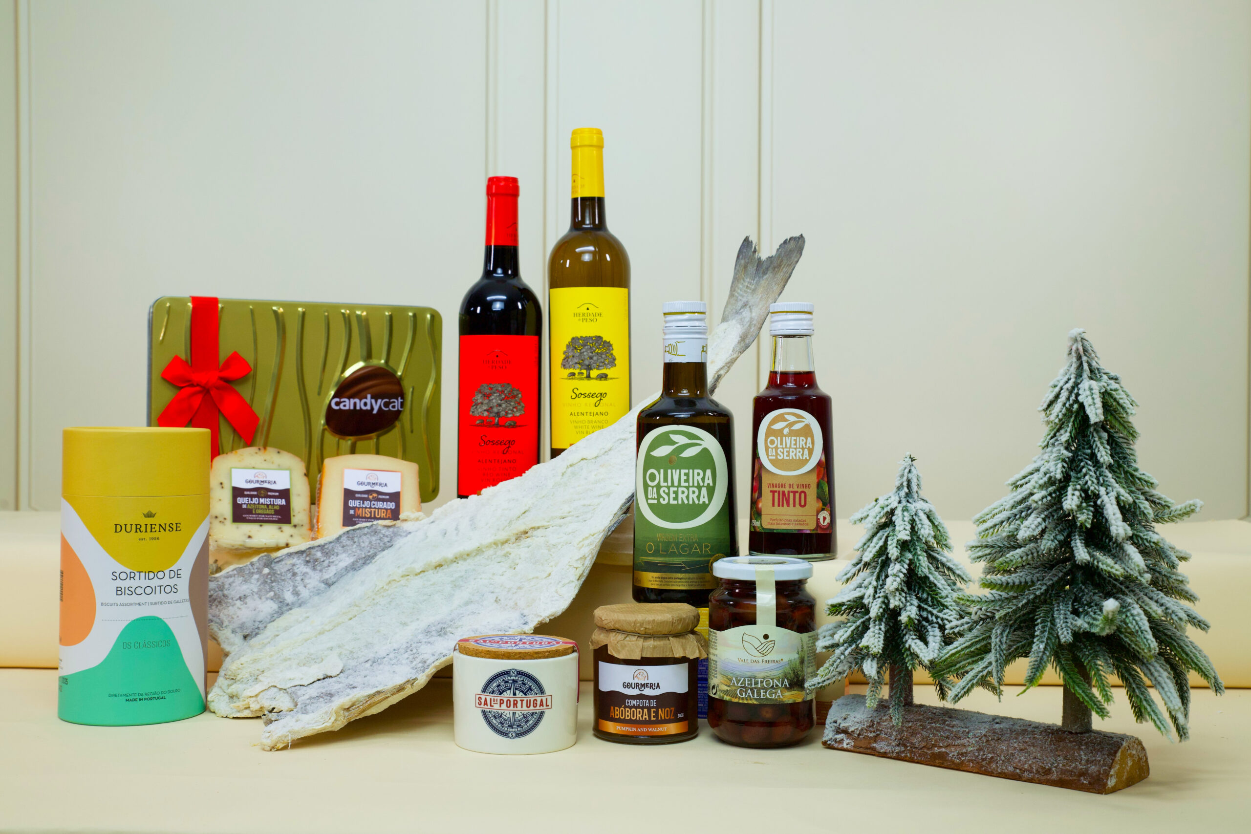 Cabaz gourmet corporativo com bacalhau, vinhos, azeites, sal português, compota, biscoitos, chocolates e azeitonas.
